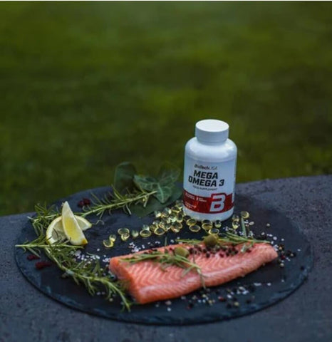 Gesunde Person nimmt eine BioTech USA Mega Omega 3 Kapsel als Teil der täglichen Routine